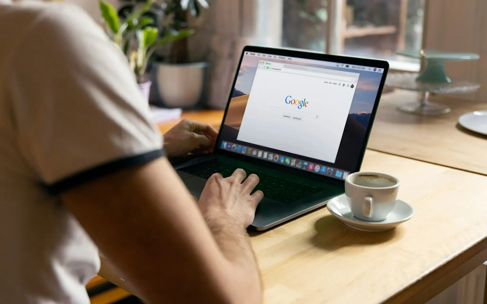 Επιχειρηματίας αναζητά στη Google από laptop, με καφέ δίπλα